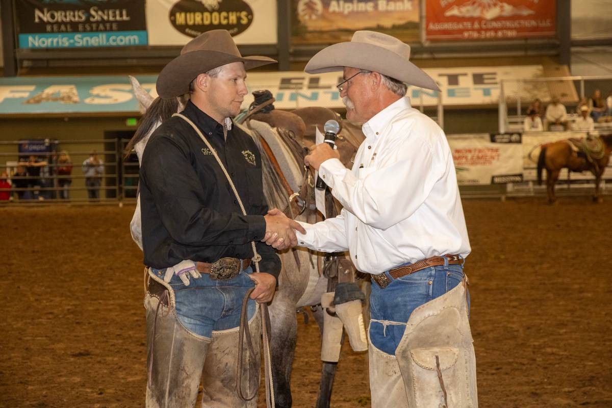 Cowboys Shaking Hands at an Indoor Rodeo Event